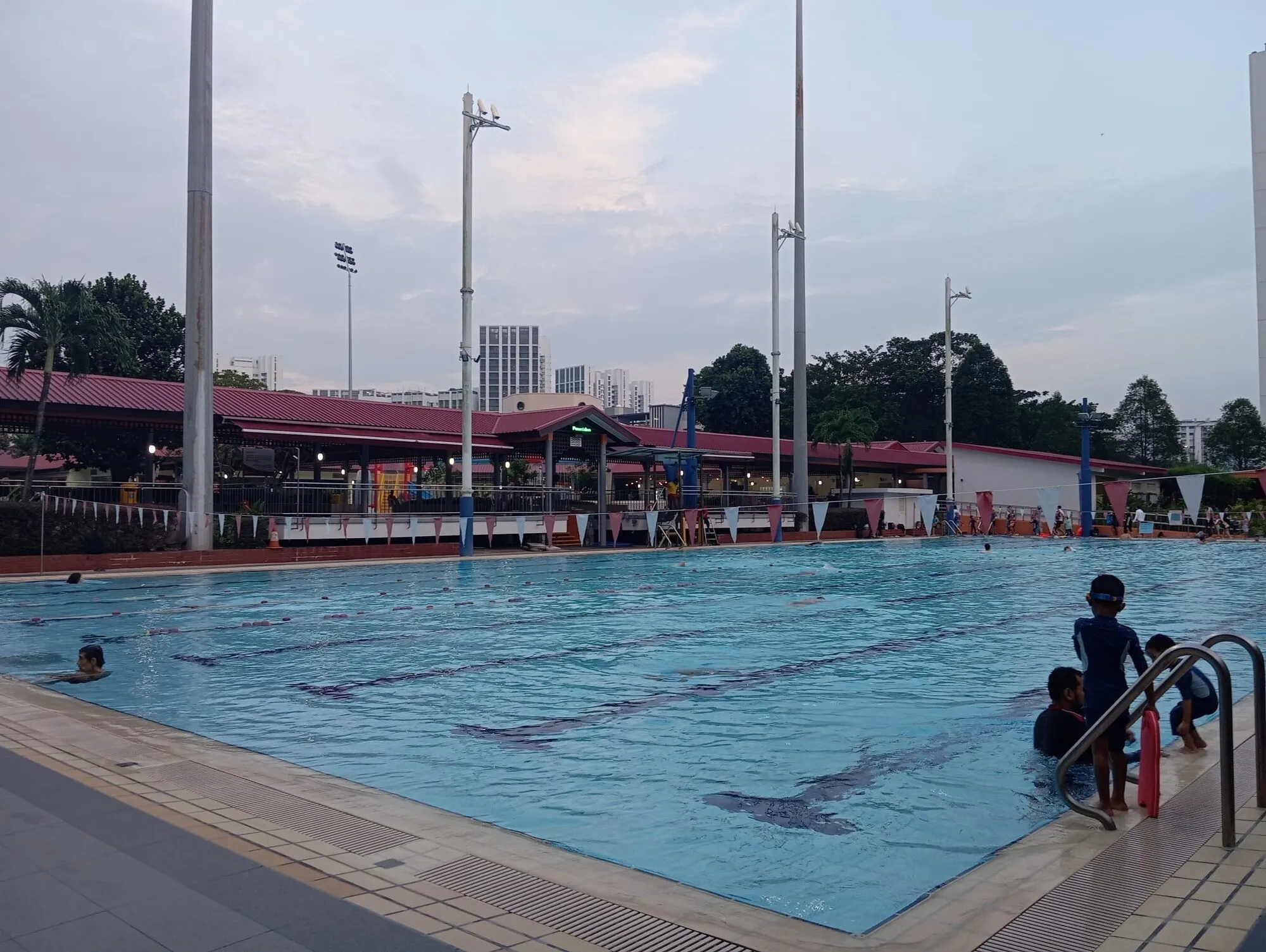 Children climbing the ladder out of the competition pool, with lane lines on the pool floor