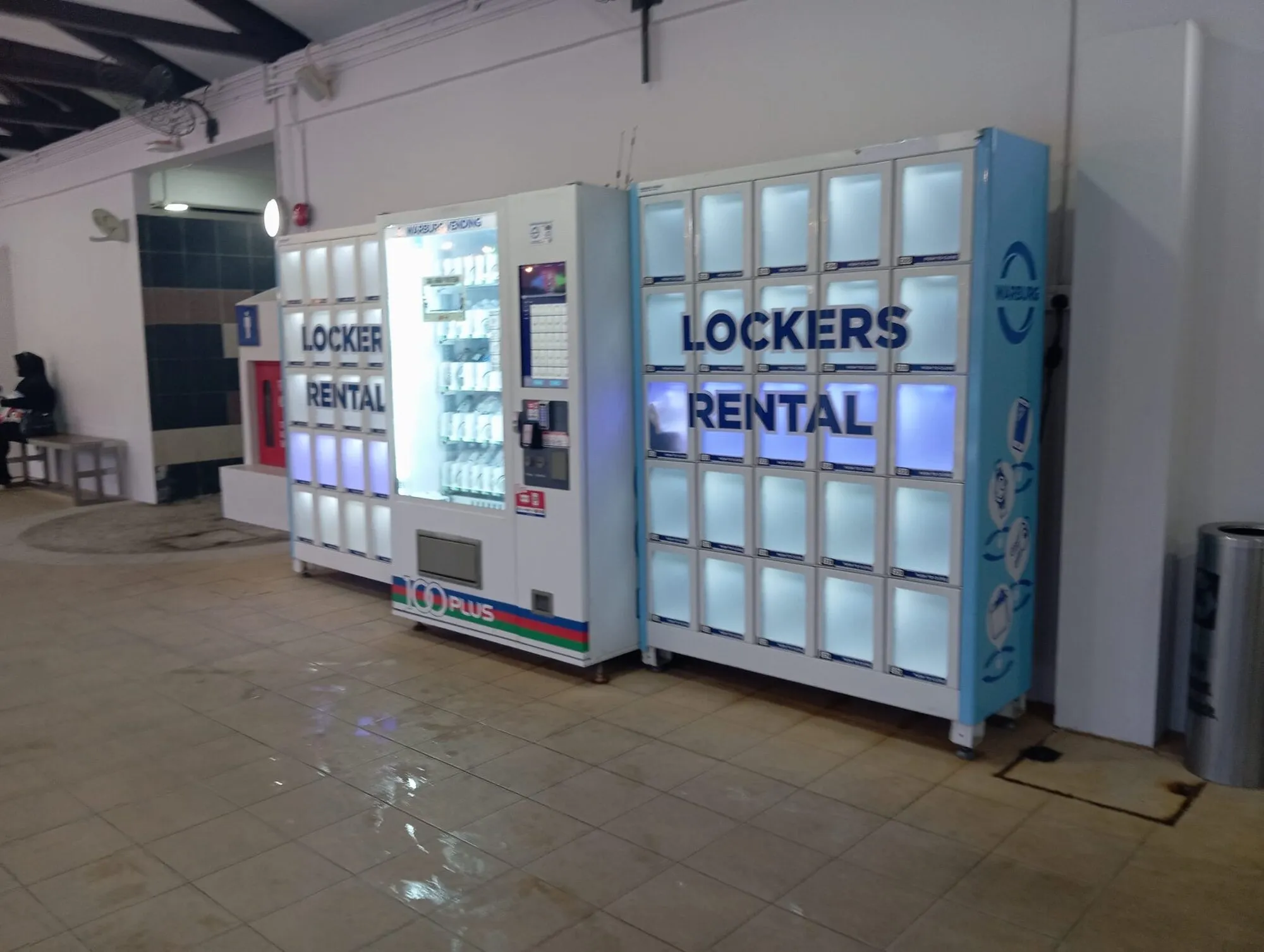 Locker rental machines and a vending machine in a corridor
