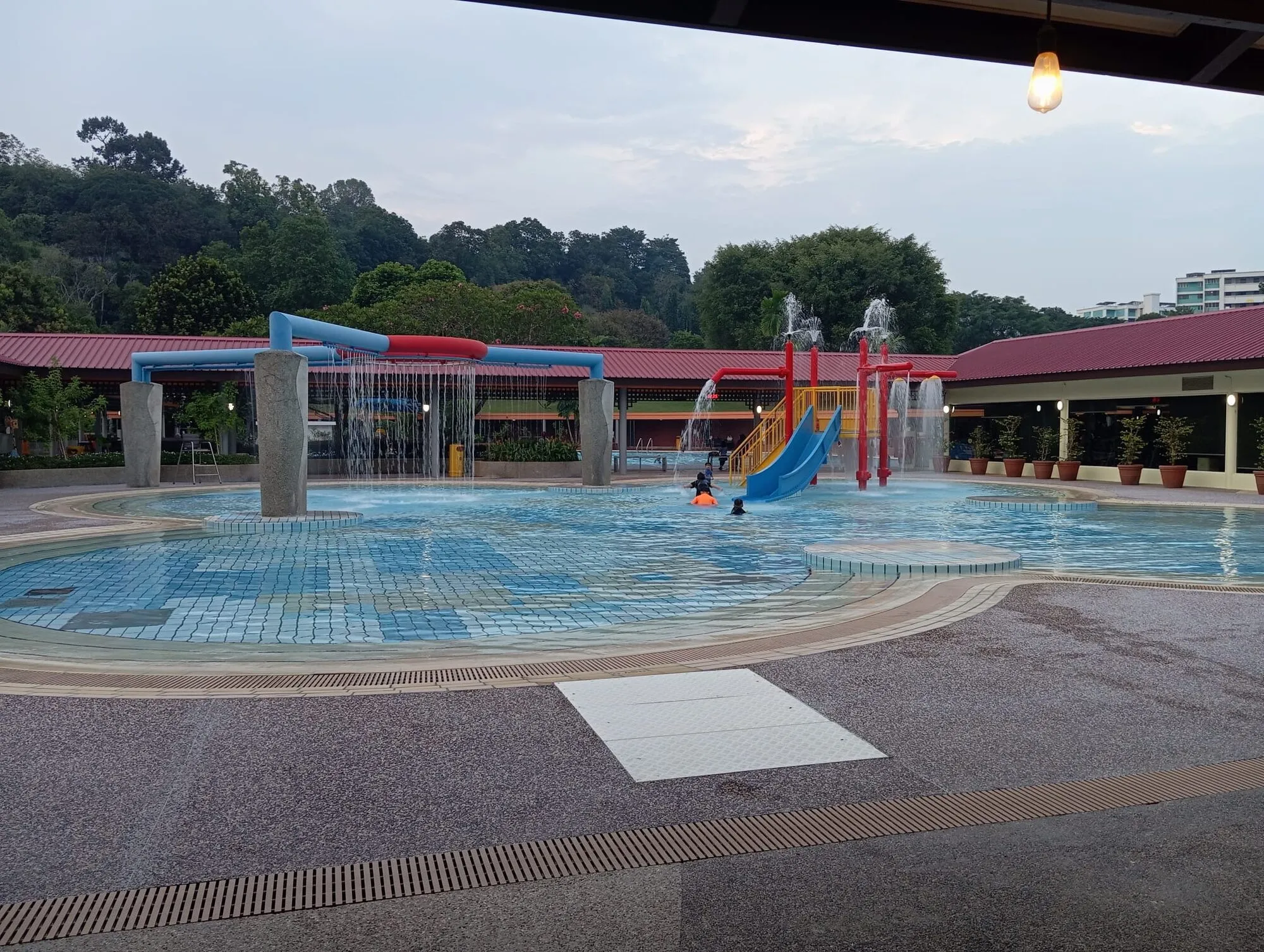 The wading pool water playground with a blue slide, tipping bucket, fountains and water arches